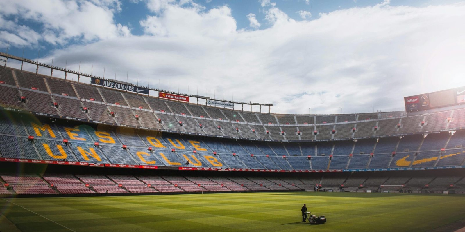 A vibrant football stadium with a well-maintained grass field under a bright sky, showcasing its iconic architecture.