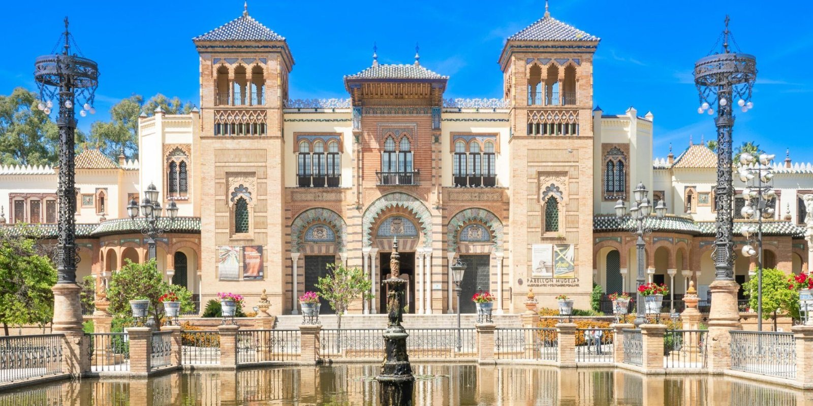 Historic architecture of Plaza de América in Seville. Andalusian building reflecting in a pond.